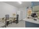 Galley kitchen with white cabinets and appliances plus eat in breakfast area with round table at 2819 N 75 St, Tampa, FL 33619