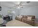 Cozy living room with neutral tile floors, ceiling fan and a comfortable couch by a bright window at 2819 N 75 St, Tampa, FL 33619
