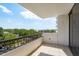 Balcony featuring a tiled floor and a railing with green trees and a blue sky in the background at 30 Turner St # 502, Clearwater, FL 33756
