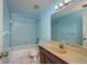 Bathroom offering blue walls, ample vanity storage, and a shower-tub combo with blue tile at 30 Turner St # 502, Clearwater, FL 33756