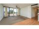 Bright living room with balcony access, ceiling fan, and a combination of carpet and laminate flooring at 30 Turner St # 502, Clearwater, FL 33756