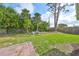 Spacious backyard with a lush grassy area and palm trees in the background at 3241 Williamsburg St, Sarasota, FL 34231