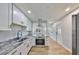 Kitchen boasting stainless steel appliances, granite counters, and sleek white cabinetry at 3241 Williamsburg St, Sarasota, FL 34231