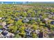 Expansive aerial view showcasing a neighborhood with lush greenery, single-Gathering homes, and city skyline backdrop at 3313 W Mullen Ave, Tampa, FL 33609