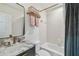 Bright bathroom features a marble-topped vanity with bronze fixtures and a shower-tub combo for a clean and functional space at 3313 W Mullen Ave, Tampa, FL 33609
