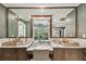 Lavish bathroom featuring dual sinks, marble countertops, and a large mirror, creating a spa-like experience at 3313 W Mullen Ave, Tampa, FL 33609