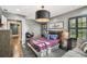 This comfortable bedroom has plaid bedding, unique artwork, and a hardwood floor at 3313 W Mullen Ave, Tampa, FL 33609