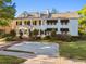 Stately two-story white home with black shutters, dormers, brick driveway, and manicured front lawn at 3313 W Mullen Ave, Tampa, FL 33609