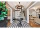 Elegant foyer with black-and-white patterned floor, staircase, statement lighting, and stylish decor at 3313 W Mullen Ave, Tampa, FL 33609