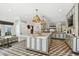 This kitchen features a large island, stainless steel appliances, custom cabinetry, a unique backsplash, and geometric-patterned floors at 3313 W Mullen Ave, Tampa, FL 33609