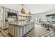 This kitchen offers custom cabinets, a large island, stainless steel appliances, geometric flooring, and breakfast nook seating at 3313 W Mullen Ave, Tampa, FL 33609