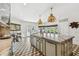 Gourmet kitchen with a large central island, ample counter space, custom cabinets, pendant lighting, and stylish geometric flooring at 3313 W Mullen Ave, Tampa, FL 33609