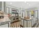 Gourmet kitchen featuring stainless steel appliances, marble countertops, unique flooring, and custom cabinets with contrasting trim at 3313 W Mullen Ave, Tampa, FL 33609