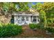 Pool house surrounded by trees and greenery with a brick walkway and white painted exterior at 3313 W Mullen Ave, Tampa, FL 33609