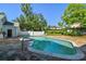 Backyard pool with stone patio and a pool house is surrounded by mature trees and greenery at 3313 W Mullen Ave, Tampa, FL 33609