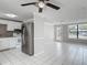 Open floorplan featuring a kitchen with stainless steel refrigerator and white cabinets at 3407 N 48Th St, Tampa, FL 33605