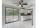 Kitchen features white cabinets and tile flooring with sliding glass door to the backyard at 3407 N 48Th St, Tampa, FL 33605