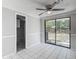 Bright living room with tile floors, ceiling fan, and sliding glass door to the backyard at 3407 N 48Th St, Tampa, FL 33605