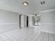Bright living room with tile floors, ceiling fan, and sliding glass door to the backyard at 3407 N 48Th St, Tampa, FL 33605