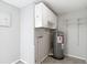 Functional utility room features an electric water heater, wall-mounted storage cabinets and metal shelving at 3407 N 48Th St, Tampa, FL 33605