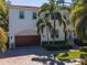 Aerial view of home with lush landscaping, barrel tile roof, and paver driveway near the water at 511 Erie Ave, Tampa, FL 33606