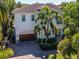 Aerial view of home with lush landscaping, barrel tile roof, and paver driveway near the water at 511 Erie Ave, Tampa, FL 33606