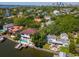 Waterfront home with swimming pool, boat dock, lush landscaping, and outdoor lounge spaces on a sunny day at 511 Erie Ave, Tampa, FL 33606