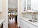 Stylish bar with white cabinets, glass shelves, marble countertops, and stainless steel sink at 511 Erie Ave, Tampa, FL 33606