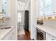 Charming bar area with wine fridge, marble countertop, white cabinetry, and glass shelving at 511 Erie Ave, Tampa, FL 33606