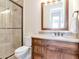 Bathroom showcasing wood vanity with granite countertop and framed glass shower at 511 Erie Ave, Tampa, FL 33606
