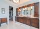 Bathroom featuring dark wood double vanity, and walk-in closet with shelving for storage at 511 Erie Ave, Tampa, FL 33606
