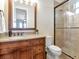 Bathroom with dark wood vanity with granite countertop and framed glass shower at 511 Erie Ave, Tampa, FL 33606