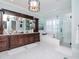 Bright bathroom with dark wood vanity, soaking tub, glass shower, and decorative chandelier at 511 Erie Ave, Tampa, FL 33606