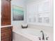 Bathroom featuring a soaking tub, dark wood vanity, and plantation shutters at 511 Erie Ave, Tampa, FL 33606