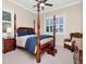 Bedroom featuring a four-poster bed, shuttered windows, and a woven chair at 511 Erie Ave, Tampa, FL 33606