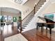 Spacious foyer with hardwood floors, grand piano, and staircase leading to the living area at 511 Erie Ave, Tampa, FL 33606
