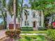 Elegant two-story home features a stucco facade, arched entry, and lush tropical landscaping at 511 Erie Ave, Tampa, FL 33606