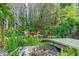 Lush backyard retreat featuring a serene seating area with comfortable red Adirondack chairs surrounded by tropical foliage at 7816 Citrus Blossom Dr, Land O Lakes, FL 34637
