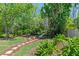 Lush backyard featuring a stone pathway, mature trees, and serene landscaping for outdoor enjoyment at 7816 Citrus Blossom Dr, Land O Lakes, FL 34637