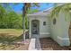 Charming home entrance with an arched doorway and decorative oval window, surrounded by lush landscaping and a peaceful setting at 7816 Citrus Blossom Dr, Land O Lakes, FL 34637