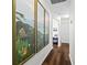Hallway featuring beach-themed artwork, hardwood floors, and access to other rooms in the house at 7816 Citrus Blossom Dr, Land O Lakes, FL 34637