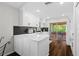 Modern kitchen featuring white cabinets, quartz countertops, and stainless steel appliances with access to the porch at 7816 Citrus Blossom Dr, Land O Lakes, FL 34637