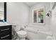 Bright bathroom featuring a soaking tub with tile surround and a black vanity with countertop space at 7816 Citrus Blossom Dr, Land O Lakes, FL 34637