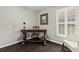 Well-lit home office with shuttered window, unique desk, and dark wood floors at 7816 Citrus Blossom Dr, Land O Lakes, FL 34637