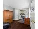 Office area featuring a wooden armoire and desk against gray walls and dark hardwood floors at 7816 Citrus Blossom Dr, Land O Lakes, FL 34637