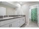 Bathroom with double sink vanity, granite counters, white cabinetry, and a shower with green curtain at 8749 Parsons Hill Blvd, Wesley Chapel, FL 33545