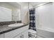 Clean bathroom with vanity, granite countertop, sink, toilet, and shower with a decorative curtain at 8749 Parsons Hill Blvd, Wesley Chapel, FL 33545