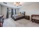 Well-lit bedroom featuring a ceiling fan, large window, and comfortable furnishings, including a crib at 8749 Parsons Hill Blvd, Wesley Chapel, FL 33545