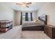 Well-lit bedroom featuring a ceiling fan, large window, and comfortable furnishings, including a crib at 8749 Parsons Hill Blvd, Wesley Chapel, FL 33545