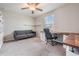 Bedroom featuring carpet, ceiling fan, window, a desk, couch and shelving at 8749 Parsons Hill Blvd, Wesley Chapel, FL 33545
